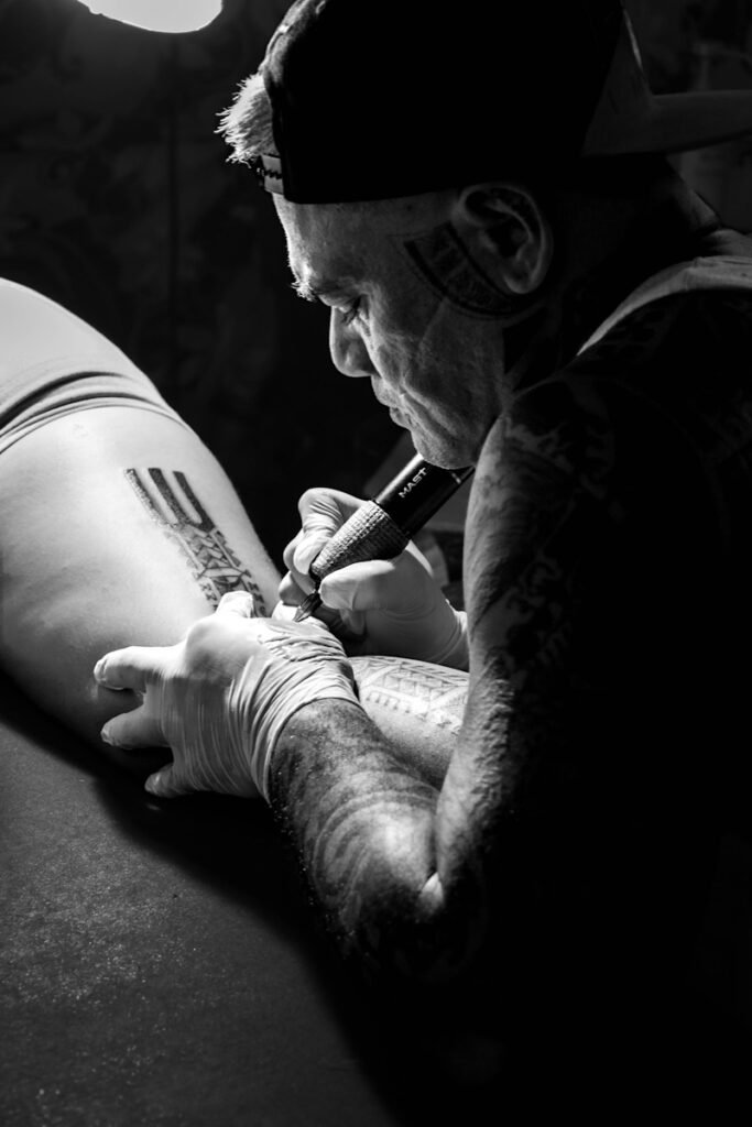 tattoo artist en train de tatouer la cuisse d'une femme pendant une convention de tatouage