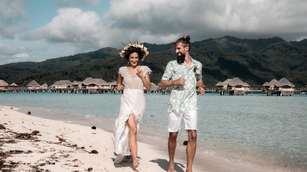 jeune mariés qui court sur une plage du Pacifique à Tahaa en Polynésie Française au Pearl Resort & Spa relais et chateaux