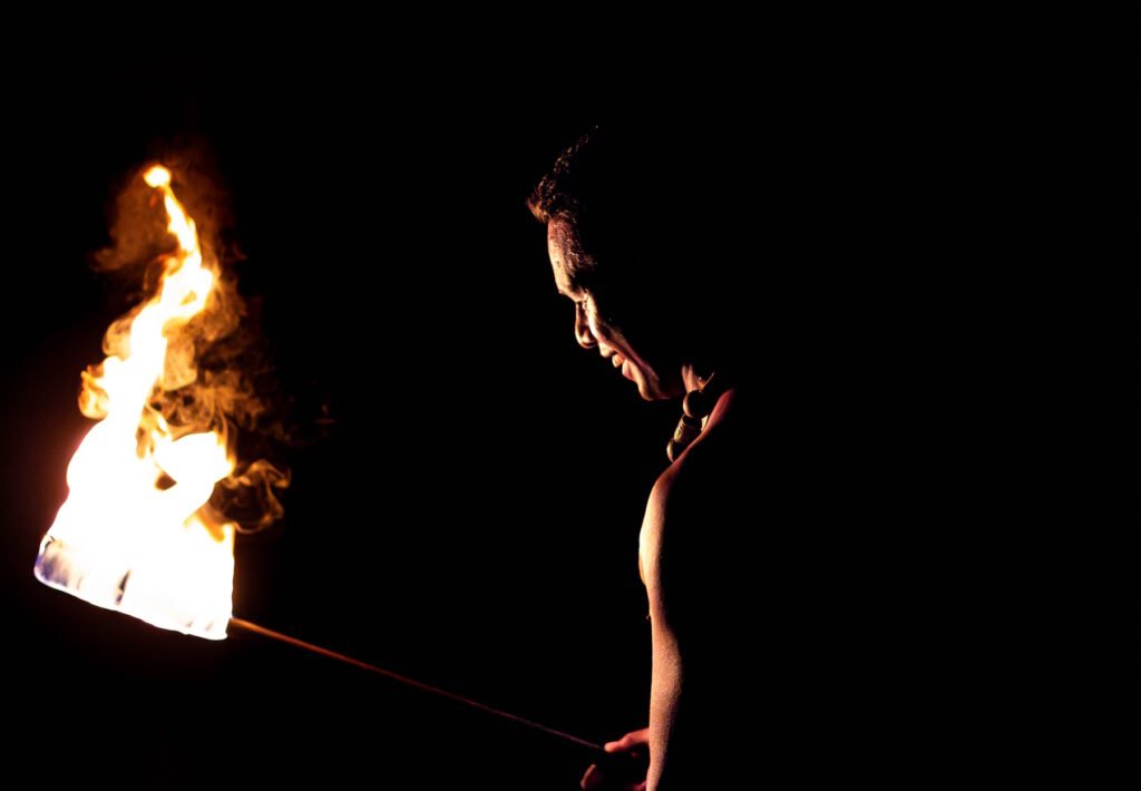 danseur du feu de profil avec sa torche à la perle de tahaa en polynésie française