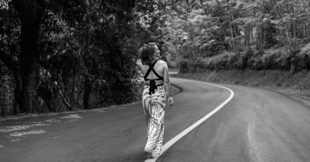 photo noir et blanc femme qui marche sur la route à moorea en polynesie française prise par marie production photographe à rennes en bretagne