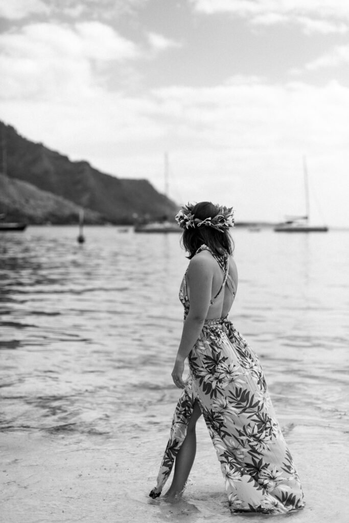 femme élégante en noir et blanc au bord de l'eau sur une plage à moorea en polynésie française photographe marie lallemant située à rennes en Bretagne