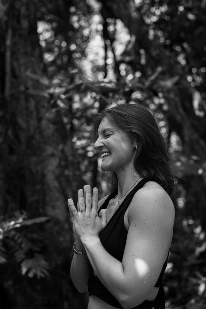 photo en noir et blanc d'une femme en position namaste au milieu de la végétation naturelle à moorea en polynesie française réalisée par marie production photographe à rennes en bretagne