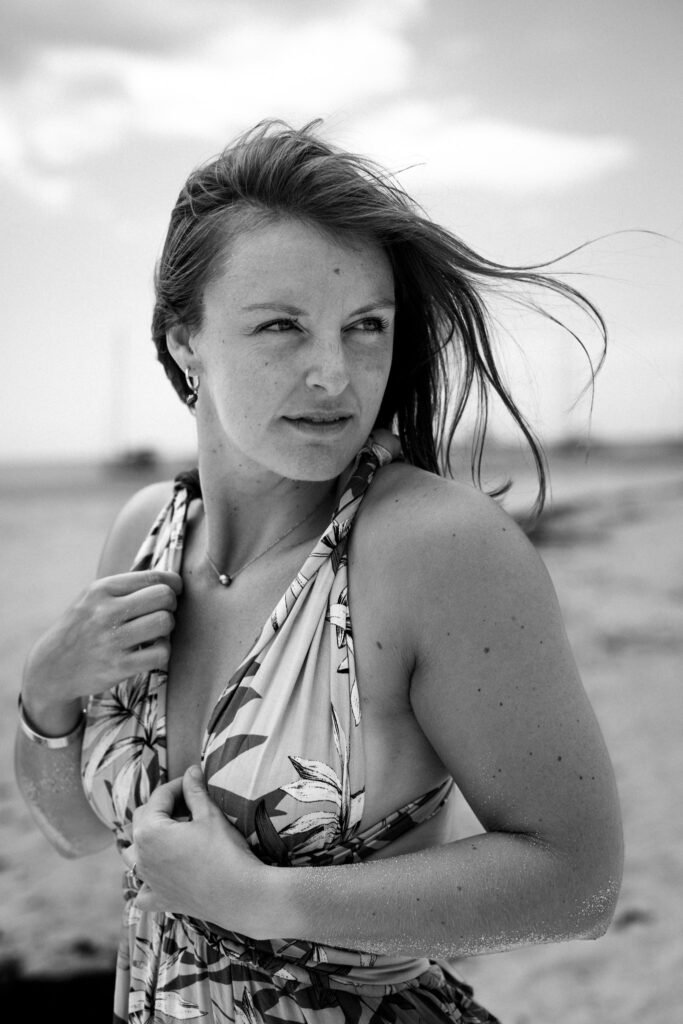 photo en noir et blanc d'une belle femme en robe d'été au bord du lagon à moorea en polynésie française prise par marie production photographe à rennes en bretagne