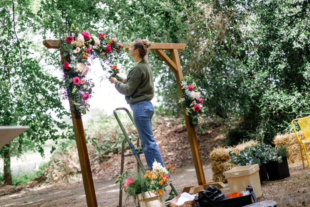 reportage documentaire savoir-faire auprès de Gwendoline, fleuriste à Moréac dans le Morbihan en Bretagne installation d'une arche avant une cérémonie laique à Saint Nolff au domaine du Porho
